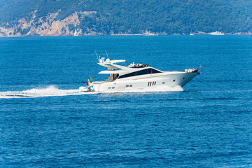 White luxury yacht or speedboat in motion on Mediterranean sea in front of the Palmaria island,...