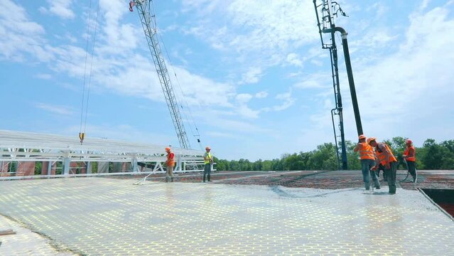 Workers are pouring concrete into the metal structure. Creating reinforced concrete floor time laps. Workers make concrete formwork time lapse frame.