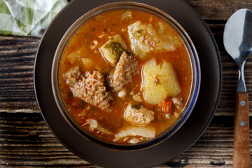 Colombian traditional tripe soup in a glass bowl on wooden table