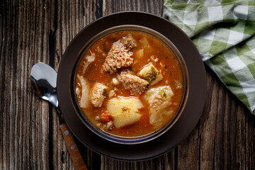 Colombian traditional tripe soup in a glass bowl on wooden table