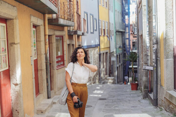 Obraz premium Pretty woman walking on a European street with a camera