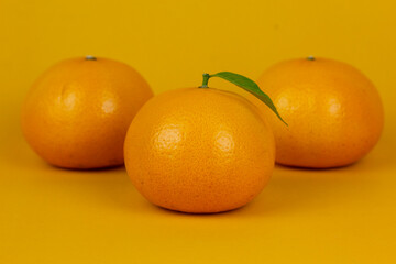 Group of three juicy orange isolated on yellow background. and Healthy oranges used in orange juice drnking concept design