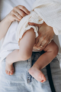 close up legs of a little newborn girl posing for a photo in her mother's arms