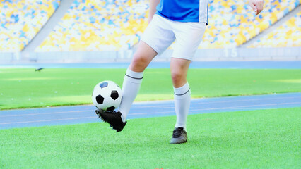 cropped view of football player in shorts bouncing soccer ball with legs