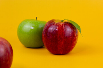 Red and green apples isolated on yellow background. Two fresh apples fruits usedd for healthy food concept and for diet apples