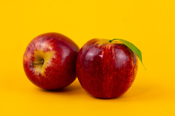Two red apples isolated on yellow background. Two fresh apples fruits used for healthy food concept  with clipping path and full depth of field