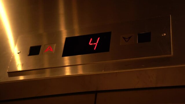 The Elevator going up. Red elevator lights showing floor numbers going up to the top.
