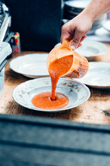 Tomatensuppe anrichten auf einem weißen Teller 
