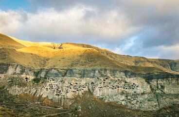 Aerial perspective of Vardzia-cave city from above with paravani river and autumn nature in foreground. Historical unesco sites Georgia.