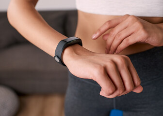 Close up of a woman touching fitness watch tracking exercise post work out
