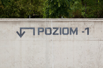 Underground parking in the city. A concrete wall with the words "level -1" and an arrow showing the direction of travel.