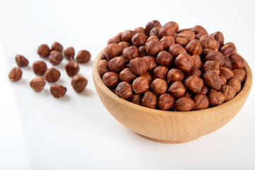 Bowl full of hazelnuts  on white background