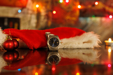 watch with the time 12:00 midnight with christmass theme and candles and reflection