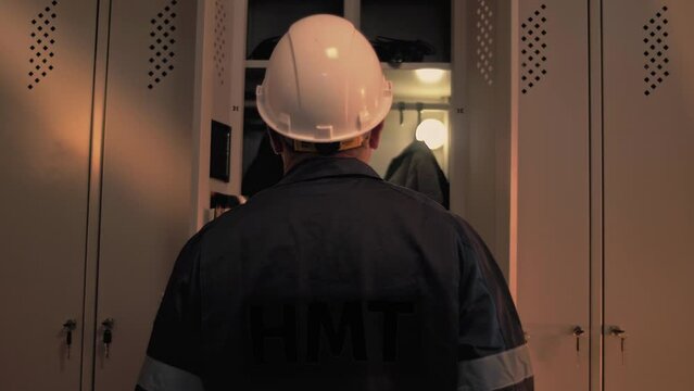 Oil refinery worker stands at his open locker