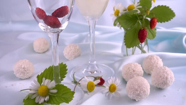 Glasses with sparkling wine, strawberries and round