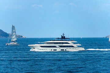 White luxury yacht and a sailing boat in motion on Mediterranean sea in front of the Palmaria and...