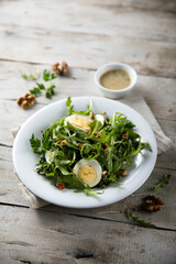 Healthy arugula salad with egg and walnut