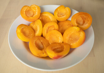 ripe, juicy apricots lie on a white plate. Energy boost, vitamins, ripe fruits, pesticides. Interruptions in the supply of fruits, imports of apricots