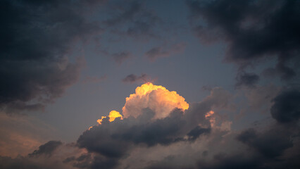 An orange cloud in the cloudy evening sky