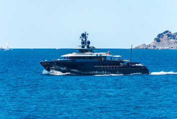 Blue and white luxury yacht in motion on Mediterranean sea in front of the Palmaria island, Porto...