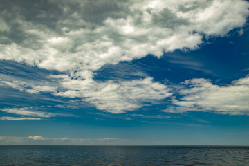 Scenic seascape of calm sea and blue sky with clouds.