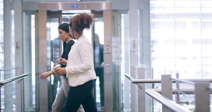 Business, travel and talking while walking with colleagues. Man and woman exit an elevator with luggage in an office or airport. Businesspeople discussing ideas and networking at a conference.