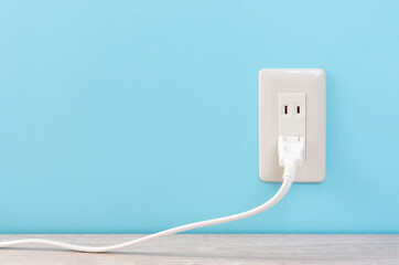 white electric outlet mounted on light blue wall....