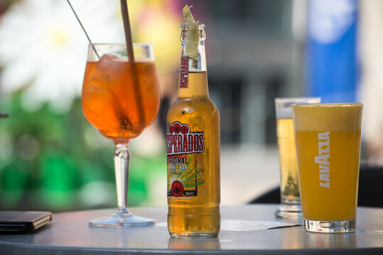 Narbonne - France - 28 July 2022 - Closeup of desperados beer, aperol spritz and orange juince at the restaurant terrace in the street