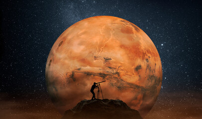 Man observing the Mars planet from top of mountain