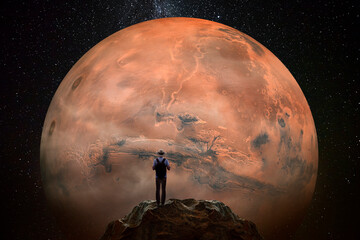 Man observing the Mars planet from top of mountain