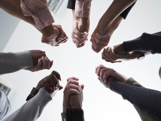People stacking hands in circle in group therapy session