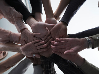 People stacking hands in circle in group therapy session - obrazy, fototapety, plakaty