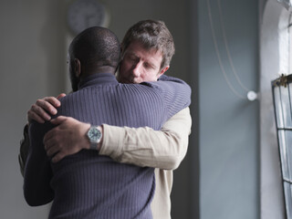 Men hugging in therapy session © Cultura Creative