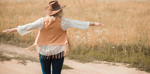 Woman Plus size in American country style black boho jacket, with a fringe, shirt and cowboy hat at...