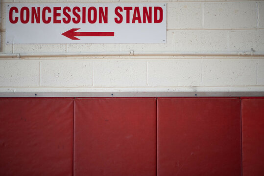 Concession stand sign on a block wall.