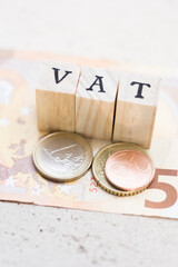 Obraz na płótnie Canvas Money and coins with the word vat. Taxes. Finance. Economy. Savings