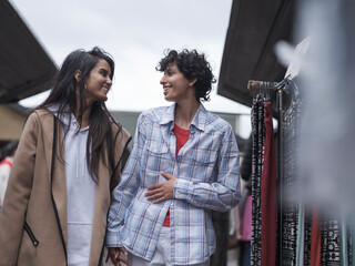 Female couple shopping in street market
