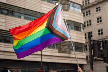 LGBT parade, person holding progress pride flag - obrazy, fototapety, plakaty