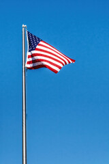 American Flag Waving In Wind Against a Deep Blue Sky