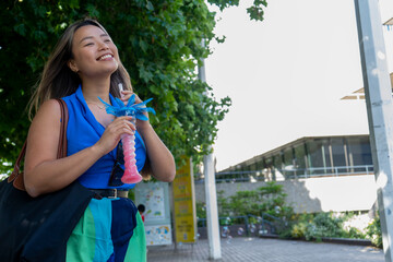 Woman holding cocktail in street