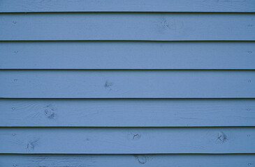 Blue wood background. The wall of the house made of blue wooden boards.