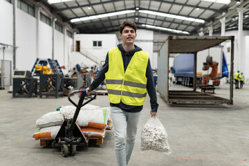 Fototapeta na wymiar Portrait of warehouse staff man carrying load with a hand truck.
