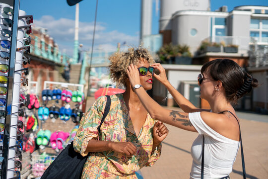 Female Couple Trying On Sunglasses