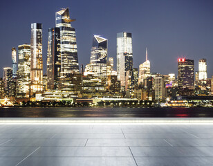 Empty concrete seafront on the background of a beautiful blurry New York city skyline at evening, mock up
