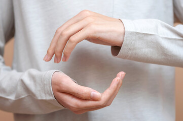 Two hands made copy space on a neutral clothing background
