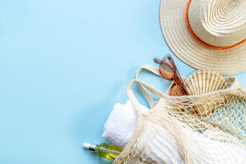 Summer background with straw hat and grid string bag. Beach flatlay