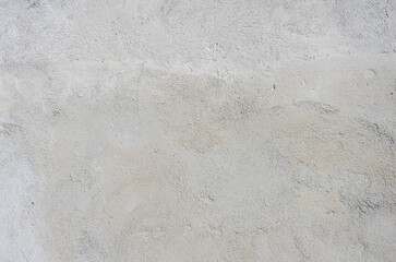A gray and dirty plastered cement wall.