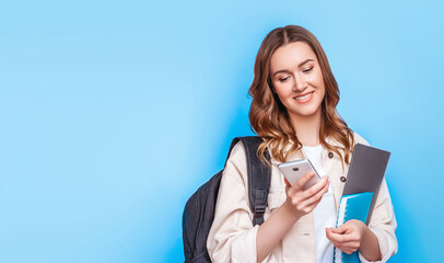 student girl using smartphone for typing messages isolated on blue background web banner