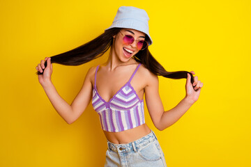 Obraz na płótnie Canvas Photo of shiny adorable girl dressed swimsuit bra cap holding hair smiling isolated yellow color background