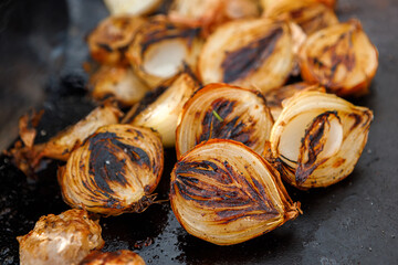 Onions cooked on the grill are on the grill.